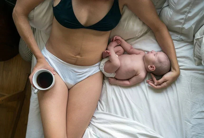 mother holding newborn during postpartum recovery at home