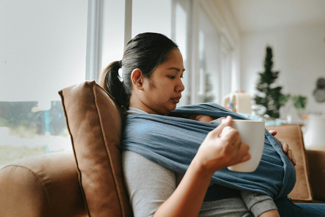 Postpartum mother resting while holding and feeding baby, supporting hormone recovery and bonding