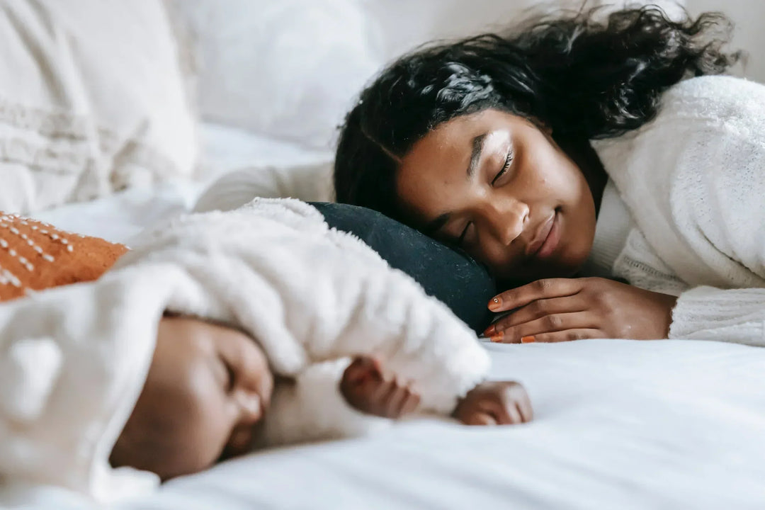 Postpartum woman lying in bed with a child