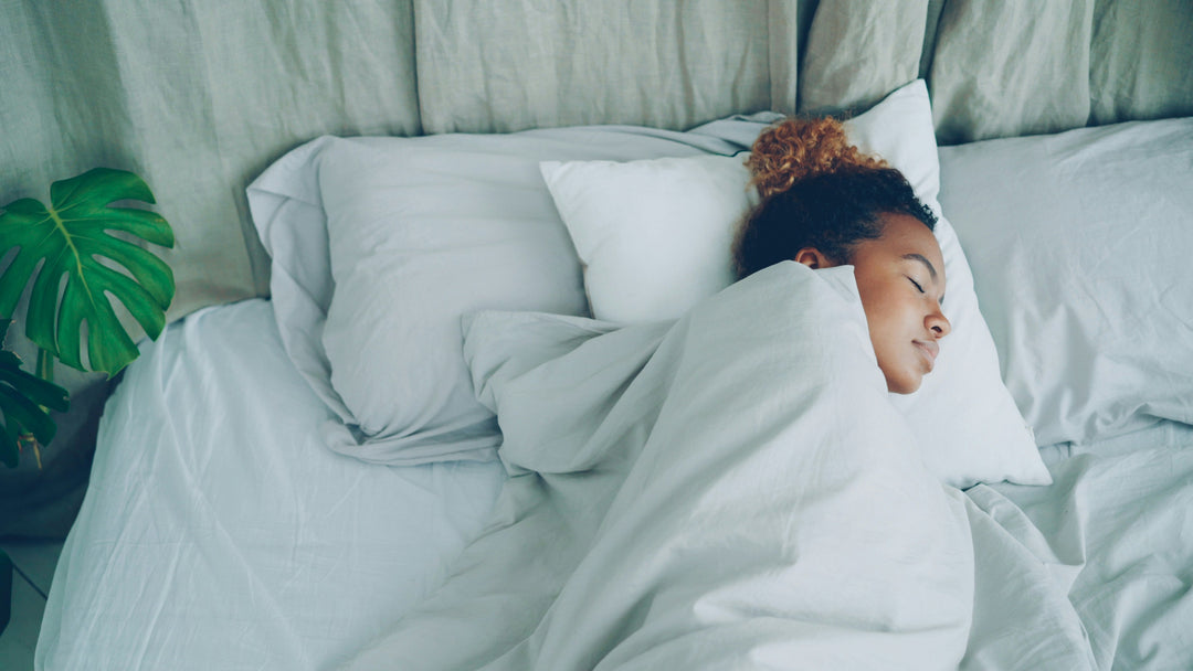 African American woman is sleeping in  bed under warm blanket 