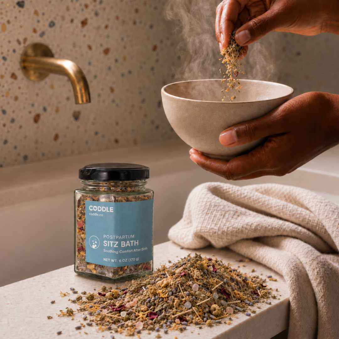 Person preparing a soothing postpartum sitz bath with CODDLE Sitz Bath botanicals in a warm, spa-inspired bathroom.