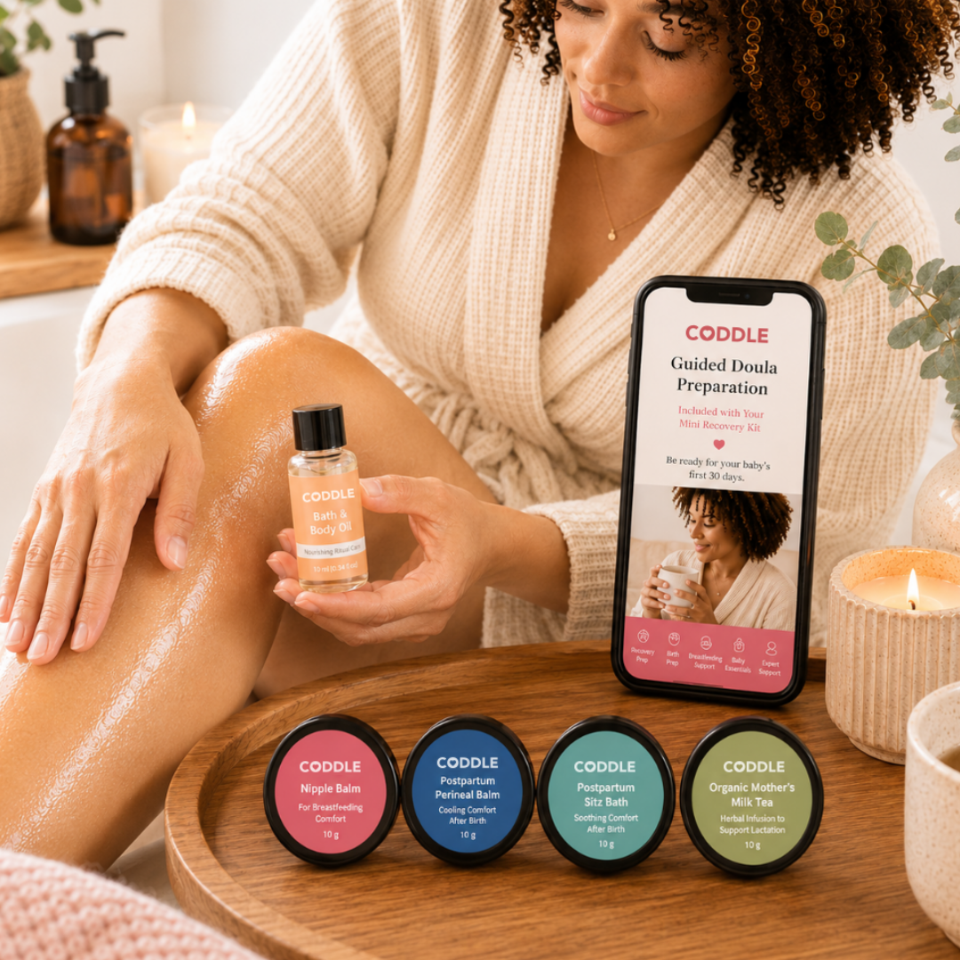 Woman using the CODDLE Mini Postpartum Recovery Kit with Bath & Body Oil, mini postpartum recovery essentials, and Guided Doula Preparation displayed on a smartphone.