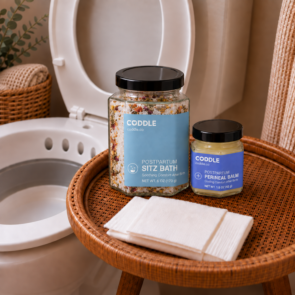 CODDLE Perineal Care After Birth Kit featuring Postpartum Sitz Bath, Postpartum Perineal Balm, postpartum wipes, and a sitz bath basin arranged in a bright bathroom for soothing postpartum recovery after birth.