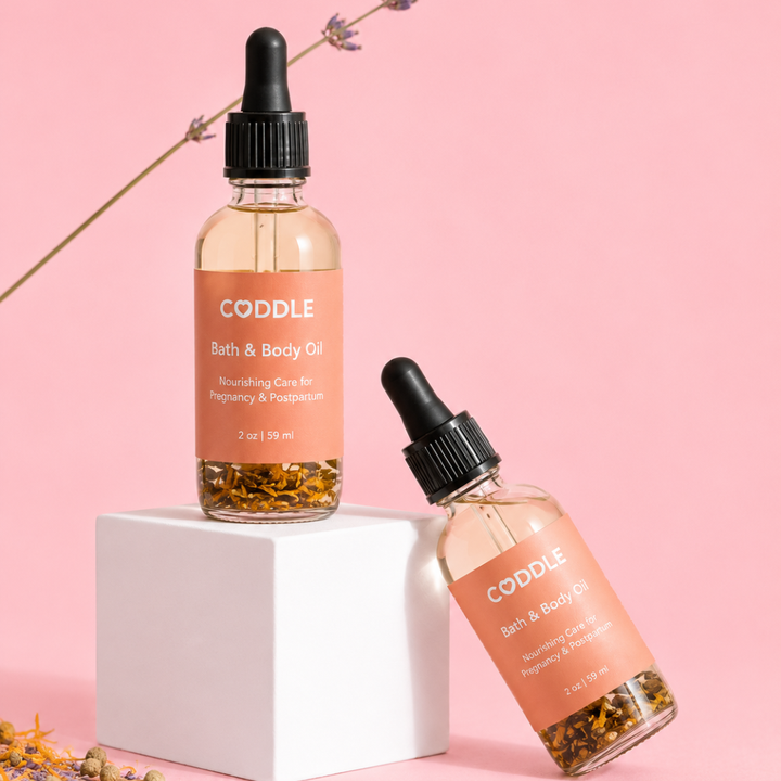 CODDLE Bath & Body Oil with lavender in a premium studio product photo featuring a blush background and white pedestal.