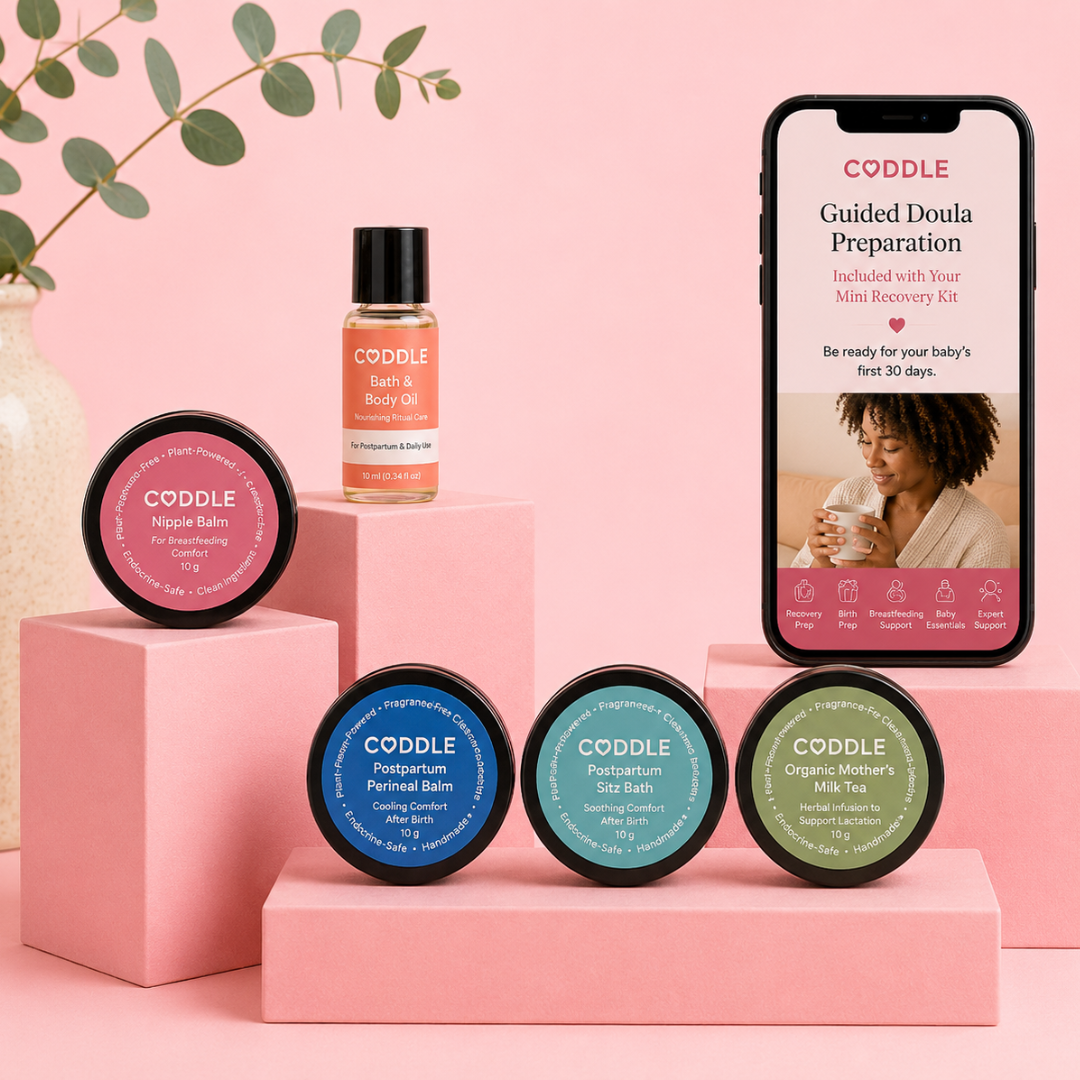 CODDLE Mini Postpartum Recovery Kit featuring Bath & Body Oil, Nipple Balm, Postpartum Perineal Balm, Postpartum Sitz Bath, Organic Mother's Milk Tea, and Guided Doula Preparation on a premium blush display