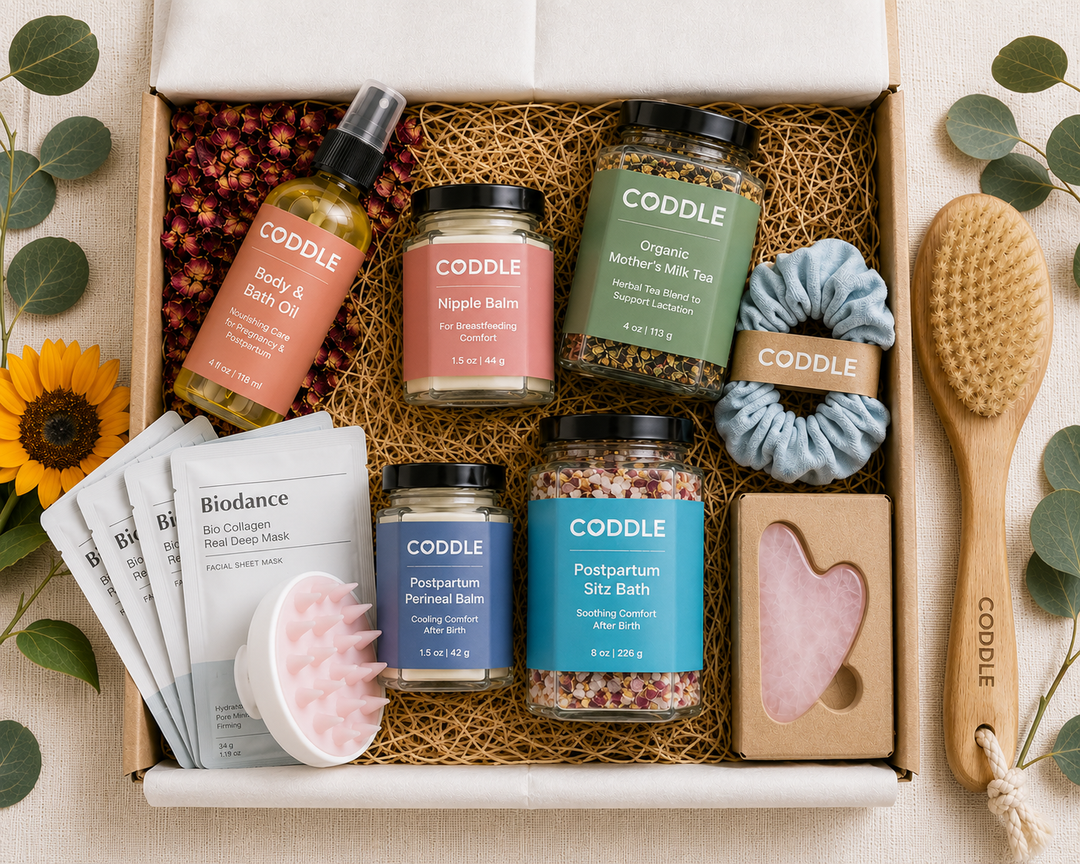 Postpartum recovery gift box with sitz bath, balms, and self-care essentials arranged in a basket.