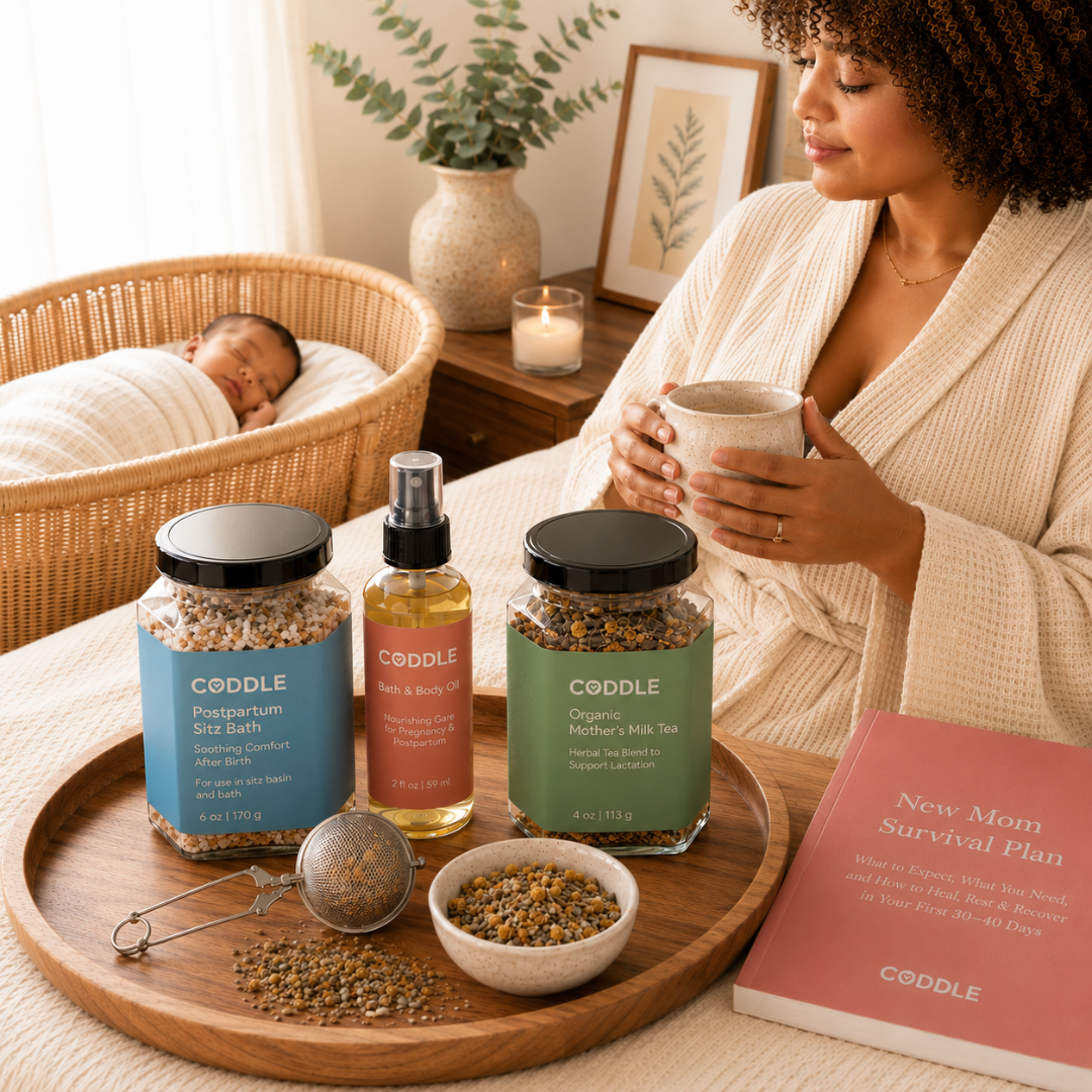 CODDLE Postpartum Recovery Kit featured in a cozy fourth trimester scene with Postpartum Sitz Bath, Organic Mother's Milk Tea, and Body & Bath Oil on a wooden tray beside a new mother enjoying tea while her baby sleeps nearby.
