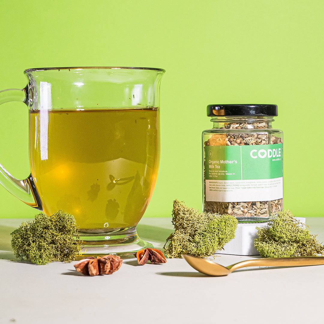 Cup of herbal lactation tea next to CODDLE mother's milk tea blend for breastfeeding support