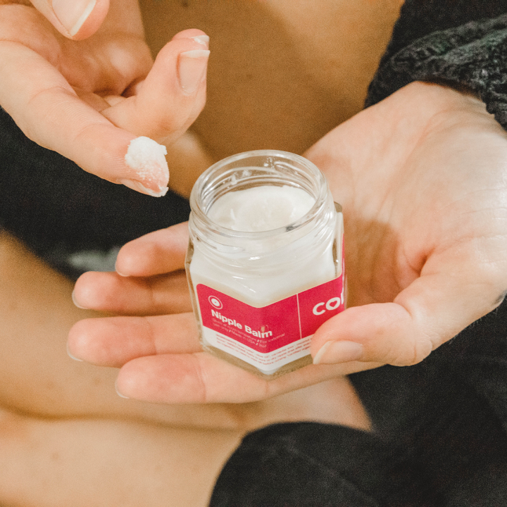 close up of postpartum nipple balm texture being scooped from jar