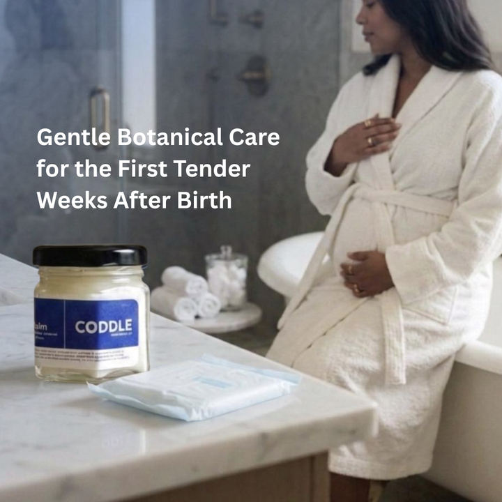 Woman in robe seated in bathroom with botanical postpartum perineal care balm nearby during early recovery after birth