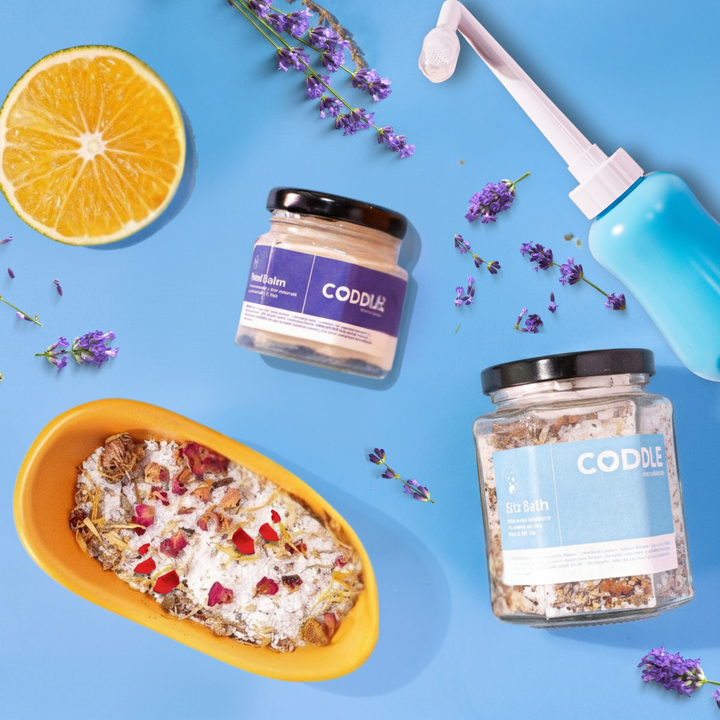 Postpartum perineal care essentials with sitz bath, peri bottle, and perineal balm.