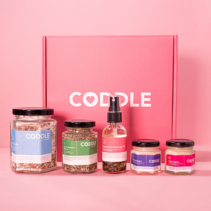 CODDLE postpartum recovery kit with herbal sitz bath, mother’s milk tea, massage oil, perineal balm and nipple balm.